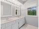 This bathroom features a marble countertop with double sinks and a window at 8934 Pinyon Ct, Indianapolis, IN 46260