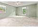 Spacious carpeted bedroom featuring a ceiling fan and natural light from two windows at 8934 Pinyon Ct, Indianapolis, IN 46260