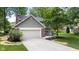 Front exterior featuring brick accents, attached two-car garage, and a well-manicured lawn at 8934 Pinyon Ct, Indianapolis, IN 46260