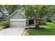 Charming front exterior featuring a well-maintained lawn, brick accents, and a two-car garage at 8934 Pinyon Ct, Indianapolis, IN 46260