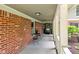 Inviting covered porch with brick walls, black steel furniture, and light fixtures at 8934 Pinyon Ct, Indianapolis, IN 46260