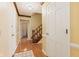 Hallway view with hardwood floors, staircase, and a glimpse of laundry room at 8934 Pinyon Ct, Indianapolis, IN 46260