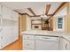 This kitchen offers bright white cabinets, a dishwasher, and a view into the adjacent living area at 8934 Pinyon Ct, Indianapolis, IN 46260