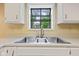 This kitchen features a stainless steel triple basin sink with a window that provides great natural light at 8934 Pinyon Ct, Indianapolis, IN 46260