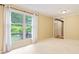 Bright living room with large windows and white curtains, plush carpet, and light yellow walls at 8934 Pinyon Ct, Indianapolis, IN 46260