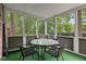 Relaxing screened porch with table, chairs, and serene wooded views at 8934 Pinyon Ct, Indianapolis, IN 46260
