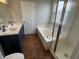 Bathroom with double sink vanity, a tub with shower and a door at 8939 Newchurch Blvd, Indianapolis, IN 46231