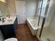 Bathroom with double sink vanity, a tub with shower and a door at 8939 Newchurch Blvd, Indianapolis, IN 46231