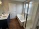 Bathroom with double sink vanity, a tub with shower and a door at 8939 Newchurch Blvd, Indianapolis, IN 46231