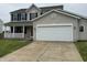 Charming two-story home with a white garage door, and a cozy front porch at 8939 Newchurch Blvd, Indianapolis, IN 46231