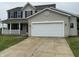 Charming two-story home with a white garage door, and a cozy front porch at 8939 Newchurch Blvd, Indianapolis, IN 46231