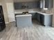 Modern kitchen with grey cabinets, stainless steel appliances, white countertops, and a large island at 8939 Newchurch Blvd, Indianapolis, IN 46231
