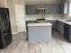 Well-lit kitchen with gray cabinets, stainless steel appliances, and an island with marble countertops at 8939 Newchurch Blvd, Indianapolis, IN 46231