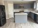 Modern kitchen with gray cabinets, stainless steel appliances, and an island with marble countertops at 8939 Newchurch Blvd, Indianapolis, IN 46231