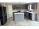 Bright kitchen with gray cabinets, stainless steel appliances, island, and wood flooring at 8939 Newchurch Blvd, Indianapolis, IN 46231