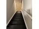 Stairway to the basement with black painted stairs and white railing at 8939 Newchurch Blvd, Indianapolis, IN 46231