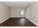 An empty bedroom with dark laminate floors, closet, one window, and neutral walls at 9206 Huntleigh Cir, Plainfield, IN 46168