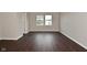 A bright bedroom with dark laminate floors, one window, and neutral walls at 9206 Huntleigh Cir, Plainfield, IN 46168