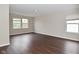 A bright bedroom with dark laminate floors, two windows, and neutral walls at 9206 Huntleigh Cir, Plainfield, IN 46168