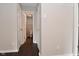 Hallway view leading to powder room, dark laminate flooring and closet space at 9206 Huntleigh Cir, Plainfield, IN 46168