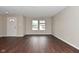 Open living area with dark hardwood flooring and bright natural light from the double windows at 9206 Huntleigh Cir, Plainfield, IN 46168