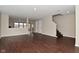 Living room features wood floors, neutral paint, and an open floor plan leading to a staircase at 9206 Huntleigh Cir, Plainfield, IN 46168