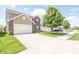 Two-story house boasts brick and shingle siding, a spacious driveway, and a manicured lawn with a mature tree at 935 Northwich Ave, Westfield, IN 46074