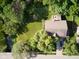 Aerial view of the property, showcasing a green lawn, mature trees, and a nearby creek at 9705 Valley Springs Blvd, Fishers, IN 46037