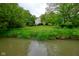 View of the home's backyard and creek, surrounded by lush trees, offering privacy and nature at 9705 Valley Springs Blvd, Fishers, IN 46037
