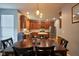 Kitchen area with dark wood dining table and chairs adjacent to wood cabinets and stainless steel appliances at 9705 Valley Springs Blvd, Fishers, IN 46037