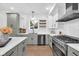 Well-lit kitchen with a modern gas range, stainless steel appliances, and white subway tile backsplash at 1027 Hosbrook St, Indianapolis, IN 46203