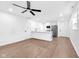 Open concept living area with wood floors, ceiling fan, and a view into the kitchen at 1027 Hosbrook St, Indianapolis, IN 46203