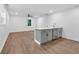 Open-concept living area with grey kitchen island, stainless appliances, and wood-look floors at 1027 Hosbrook St, Indianapolis, IN 46203