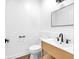 Modern powder room with wood vanity, white counter, black hardware, and stylish mirror at 1027 Hosbrook St, Indianapolis, IN 46203
