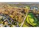Panoramic aerial view of a residential community and a golf course, surrounded by colorful fall foliage at 10759 Sawgrass Dr, Fishers, IN 46037