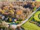An aerial shot of a residence nestled near a green golf course, vibrant trees, and a winding road at 10759 Sawgrass Dr, Fishers, IN 46037