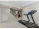 Basement featuring a treadmill, staircase, and a wet bar in the background at 10759 Sawgrass Dr, Fishers, IN 46037