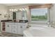 Bright bathroom showcasing a jacuzzi tub with a large window overlooking lush trees at 10759 Sawgrass Dr, Fishers, IN 46037