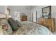 Comfortable bedroom featuring a floral bedspread, wood furniture, and a view into the primary ensuite bath at 10759 Sawgrass Dr, Fishers, IN 46037