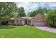 Charming brick home featuring a manicured front lawn, mature trees, and an attached two-car garage at 10759 Sawgrass Dr, Fishers, IN 46037