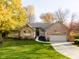 A beautifully landscaped brick home boasts a well-kept lawn, attached garage, and inviting front entrance at 10759 Sawgrass Dr, Fishers, IN 46037