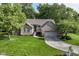 Charming brick home featuring a two-car garage, manicured lawn, and a welcoming walkway amidst lush greenery at 10759 Sawgrass Dr, Fishers, IN 46037