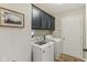 This laundry room includes overhead cabinets, washer and dryer with new vinyl floors at 10759 Sawgrass Dr, Fishers, IN 46037