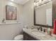Charming powder room featuring a granite countertop, elegant mirror, and decorative accents at 10759 Sawgrass Dr, Fishers, IN 46037