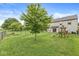 Spacious backyard featuring a lush lawn, a playset, a chain-link fence, and mature trees for privacy at 11072 Lake Run Dr, Fishers, IN 46038