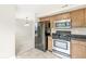 Practical kitchen layout with wood cabinets, granite countertops, stainless steel appliances, and tile flooring at 11072 Lake Run Dr, Fishers, IN 46038