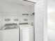 A well-lit laundry room features shelving above the washer and dryer at 11072 Lake Run Dr, Fishers, IN 46038