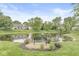 Scenic view of a tranquil pond with a park bench, surrounded by lush greenery and mature trees at 11072 Lake Run Dr, Fishers, IN 46038