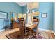 Dining area featuring wood floors, blue accent wall, and transitional lighting at 11510 Monon Farms Ln, Carmel, IN 46032