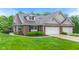 Charming brick home featuring a three-car garage and well-manicured landscaping at 11510 Monon Farms Ln, Carmel, IN 46032